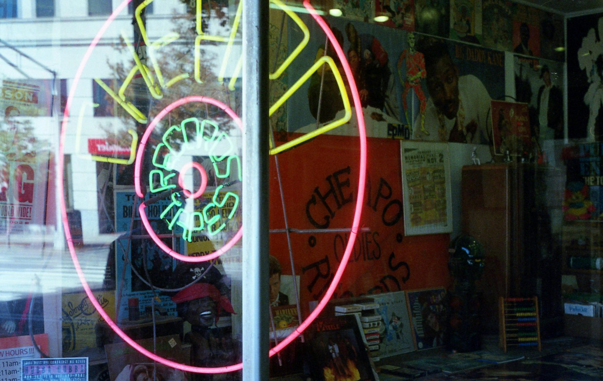 Vibrant neon sign at a retro record store in Boston showcasing vinyls and tapes.